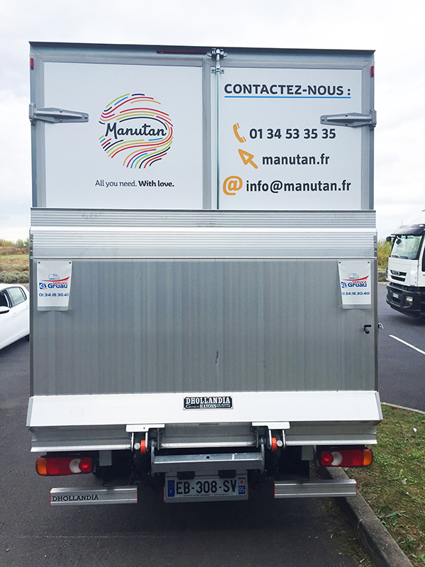 Camion Manutan Camion de transport vu de derrière sur lequel est affiché des coordonnées de Manutan